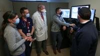 Five doctors review results on a computer screen